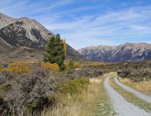 mountain and road view under blue sky at daytime photo thumbnail