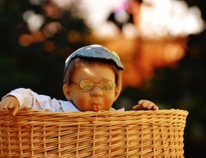 brown wicker basket with boy doll thumbnail