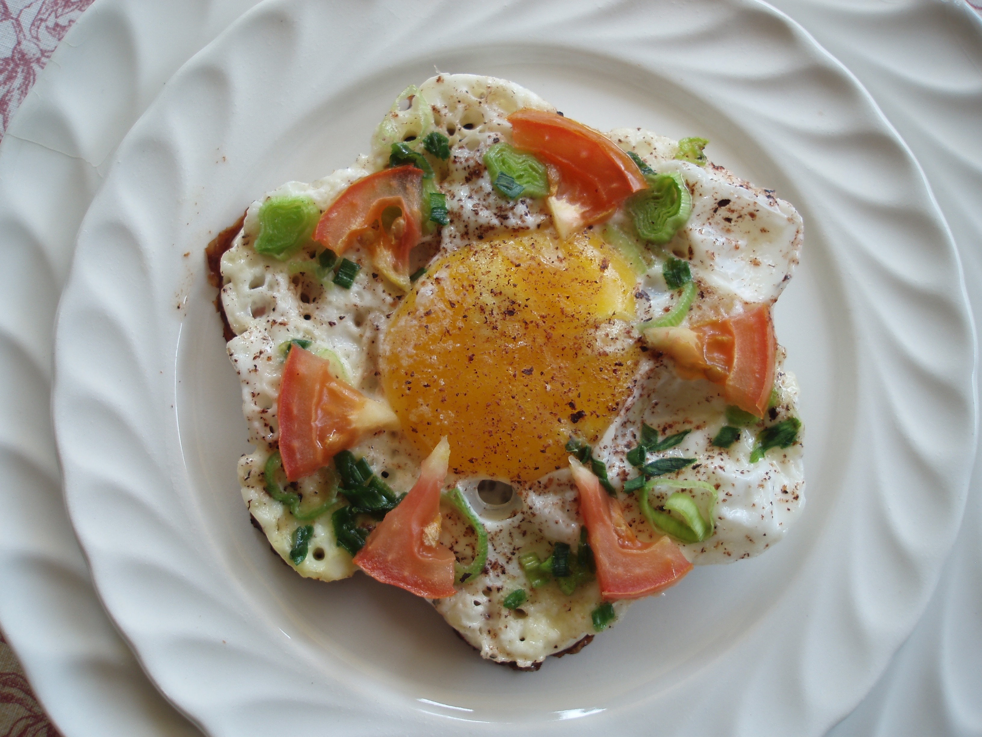 sunny side up with red tomato and green leaf vegetables