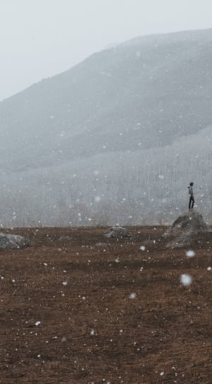 person standing on the rock during winter thumbnail
