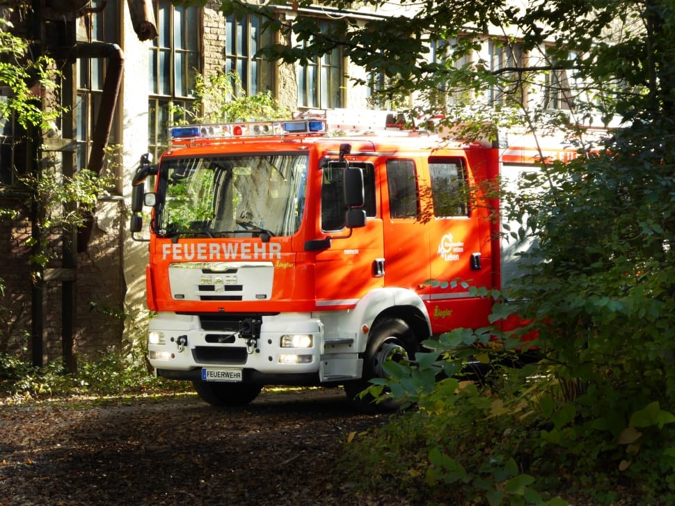 red Feuerwehr firetruck beside building during daytime preview