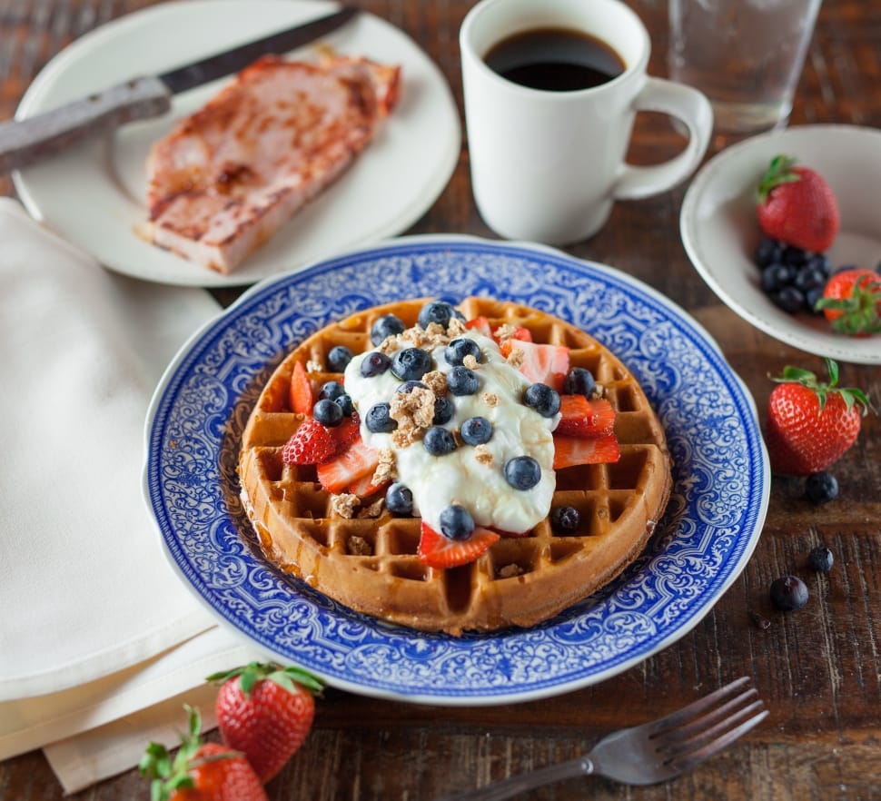 Waffle Topped With Black Round Fruit and Strawberries preview