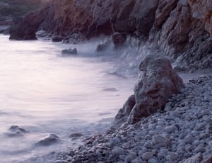 rock formation beside body of water thumbnail
