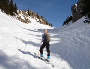 women's black pants and green snow skis thumbnail