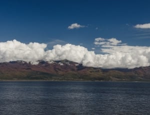 brown mountain under white clouds during daytime thumbnail