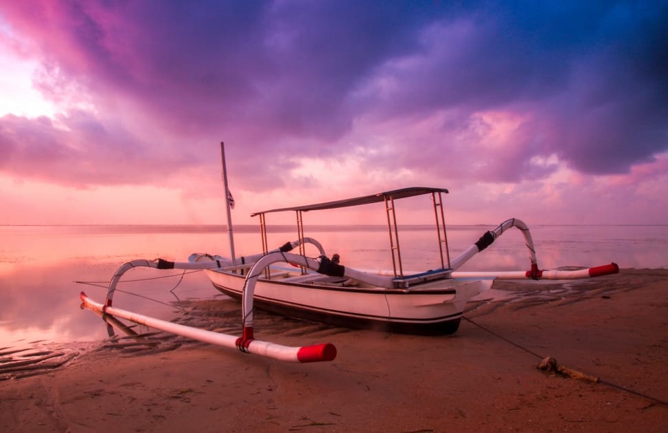 white sail boat on seashore during sunset preview