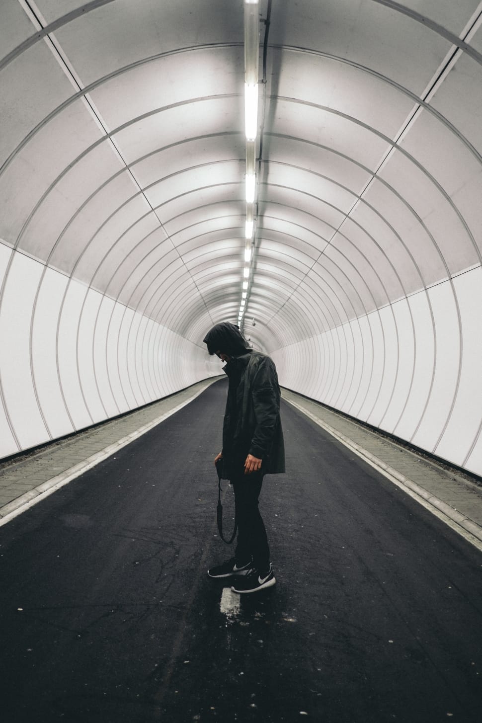 man standing in gray tunnel preview