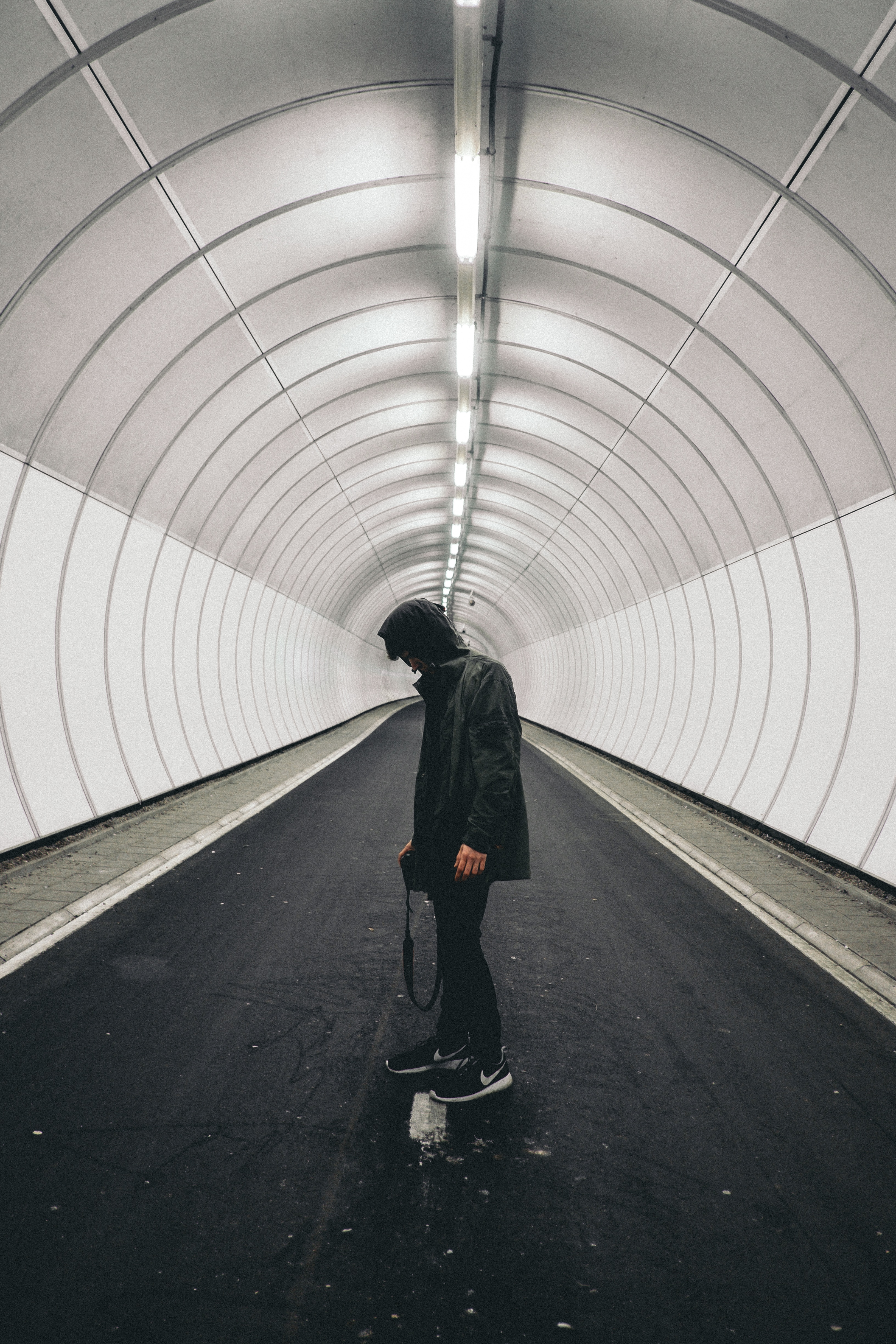 man standing in gray tunnel