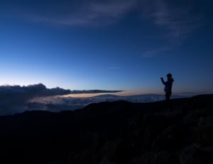 silhouette of person on muntains peak during night time thumbnail