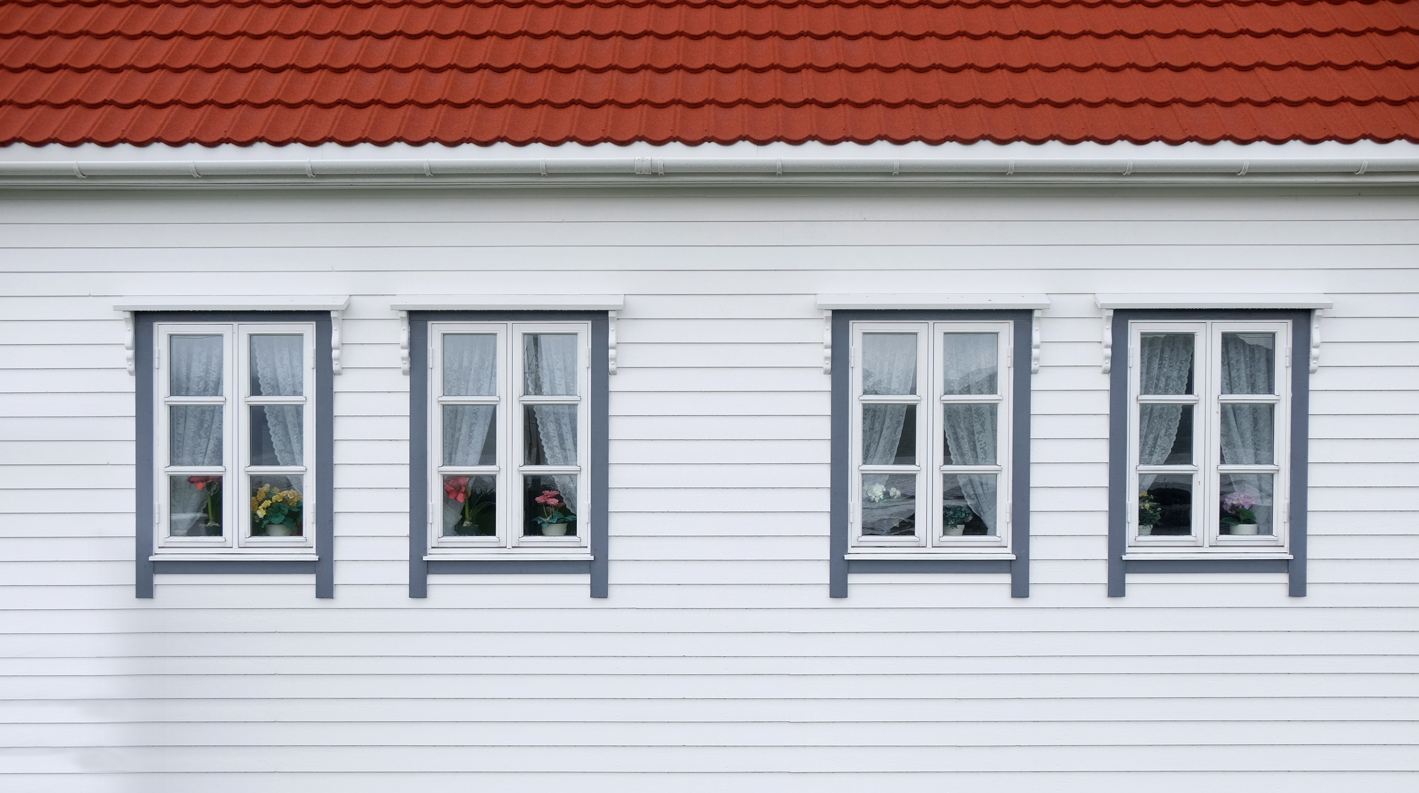 photo of white wooden wall with 4 windows