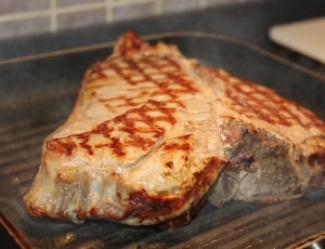 steak cooking on non-stick griddle pan thumbnail