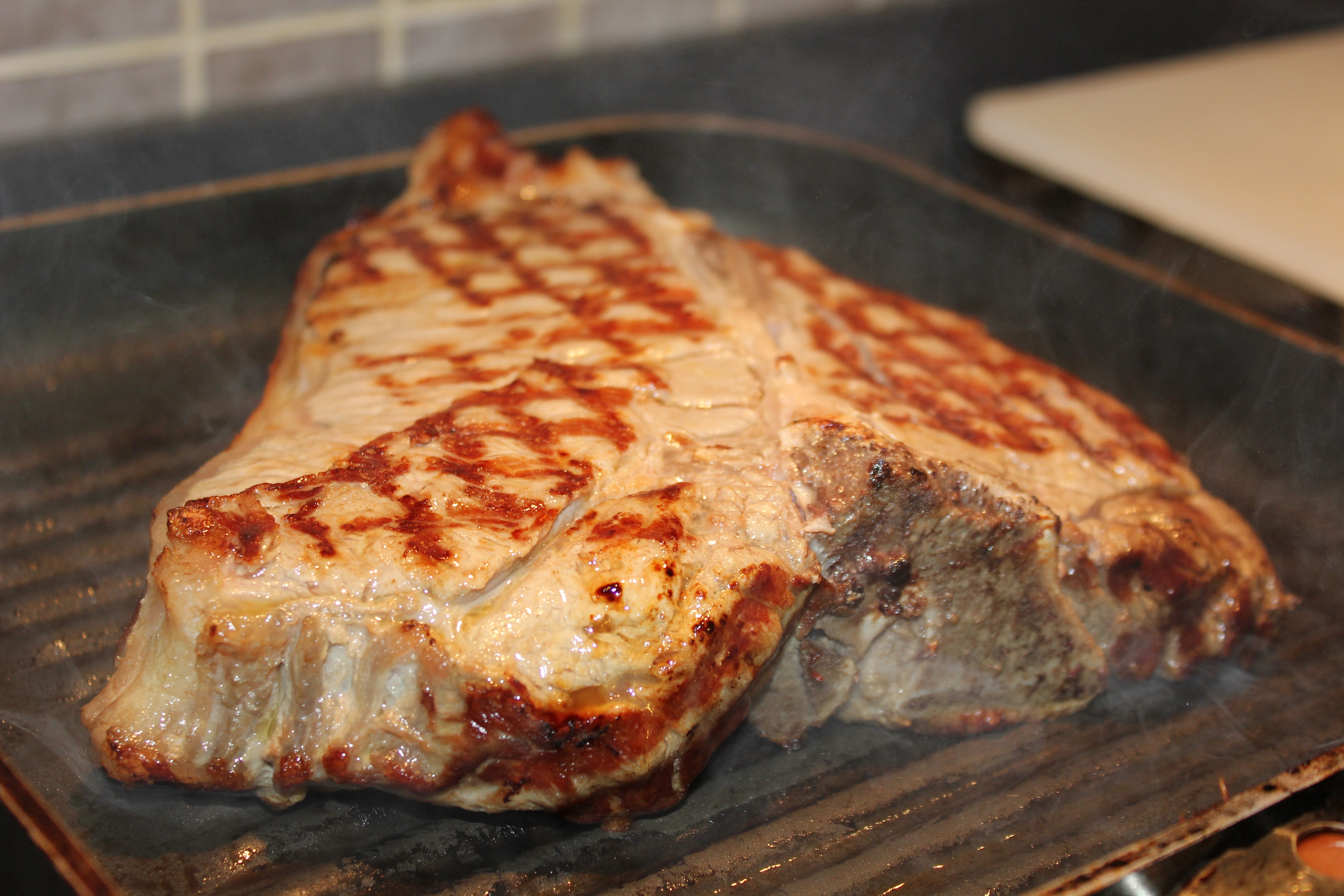 steak cooking on non-stick griddle pan