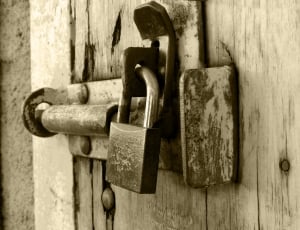 gray metal padlock in brown wooden gate thumbnail