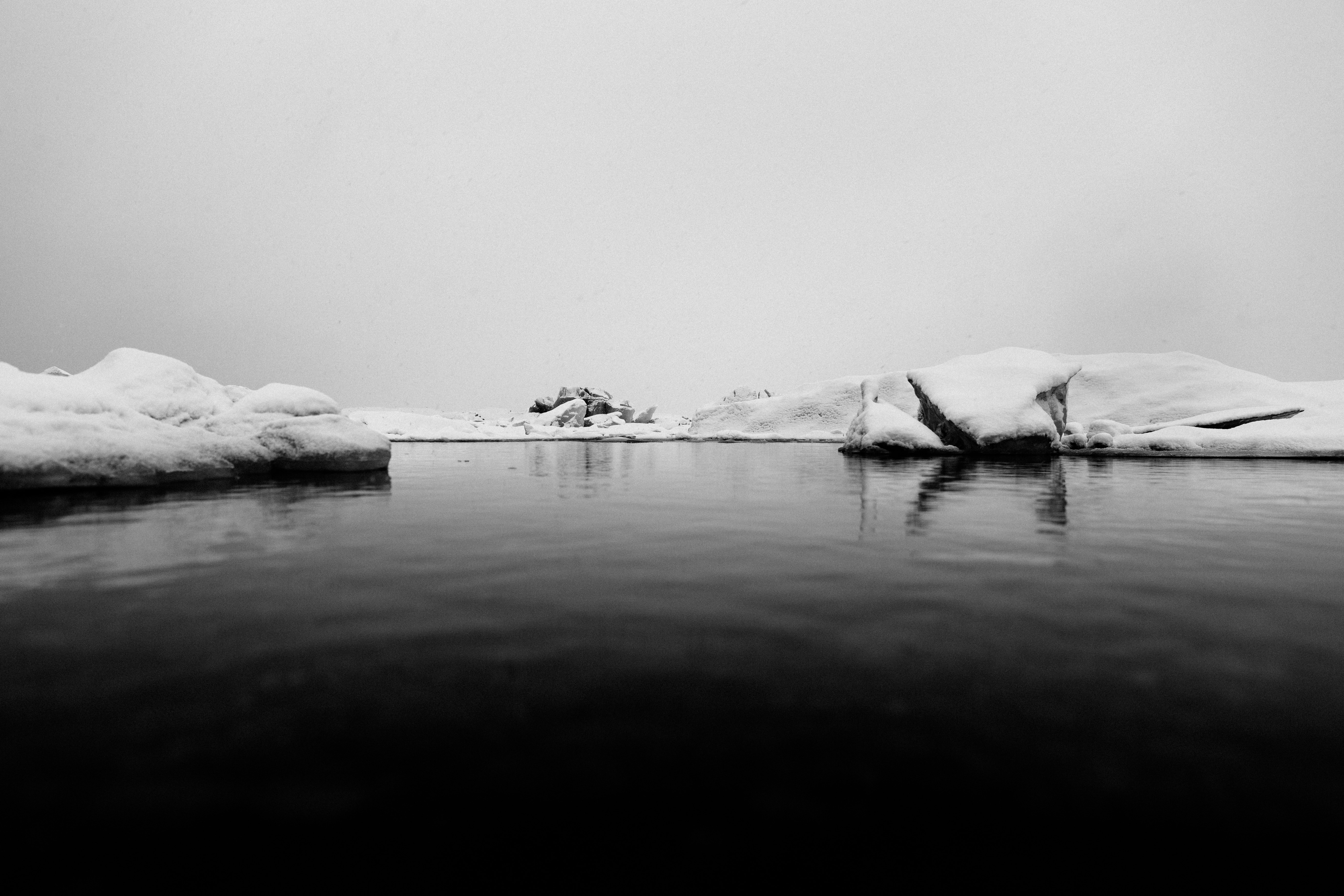 body of water surrounded by mountain covered by snow photo