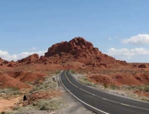 brown rocky mountain and black concrete road thumbnail