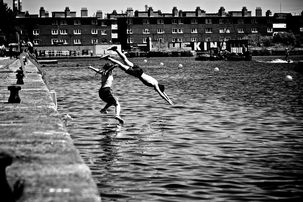 grayscale photo of man and woman diving preview