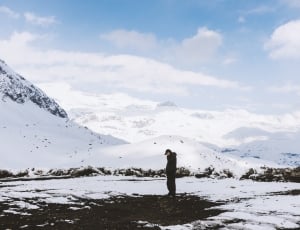 person wearing jacket standing near snow grounds thumbnail