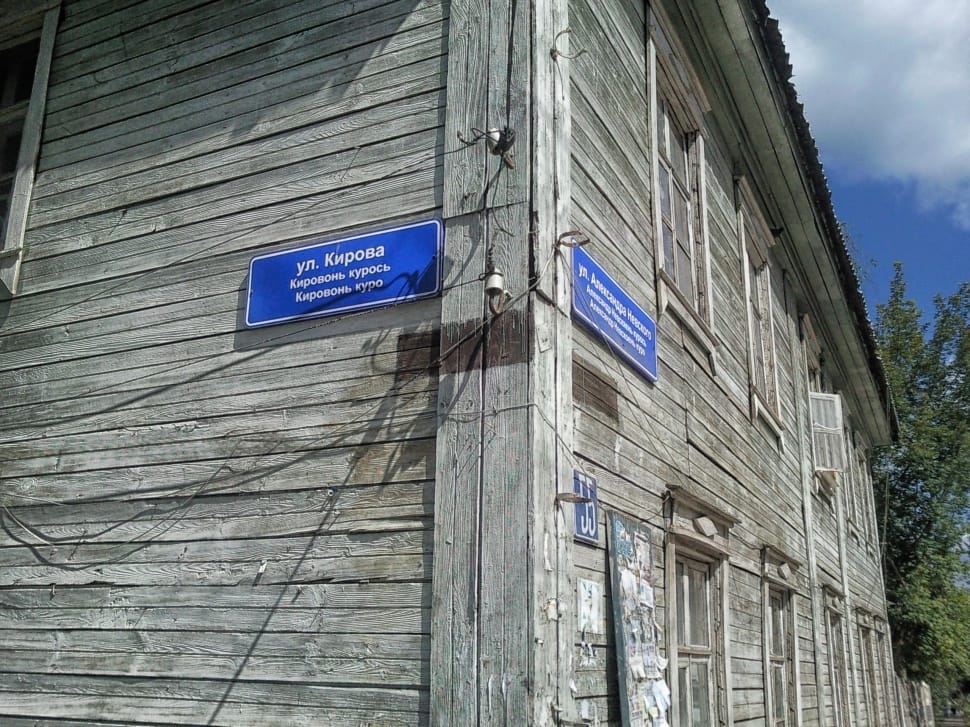blue sign on brown building with white text preview