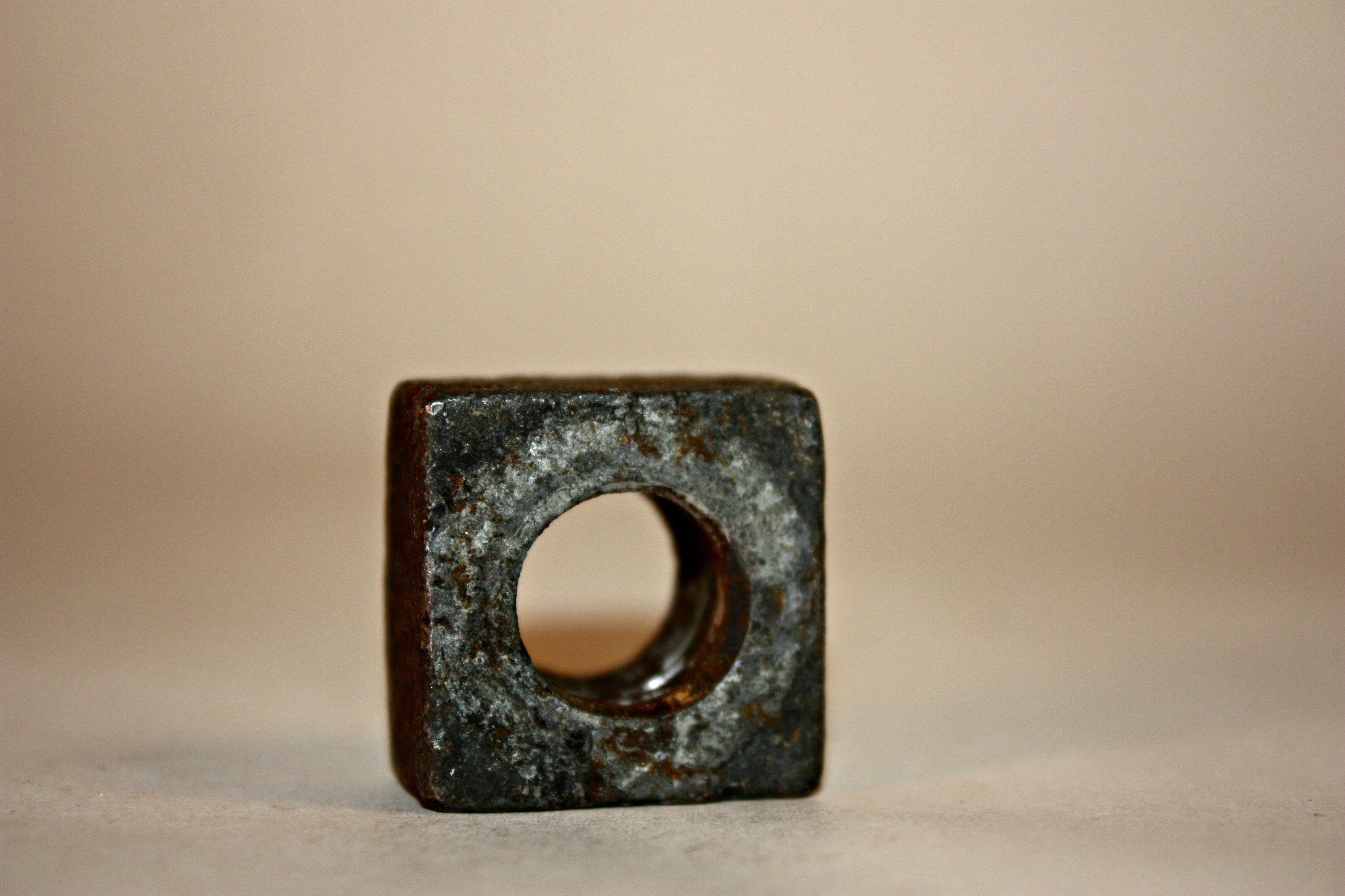 close up photography of gray metal square with hole