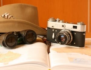black and gray milc camera black binoculars and brown cowboy hat thumbnail