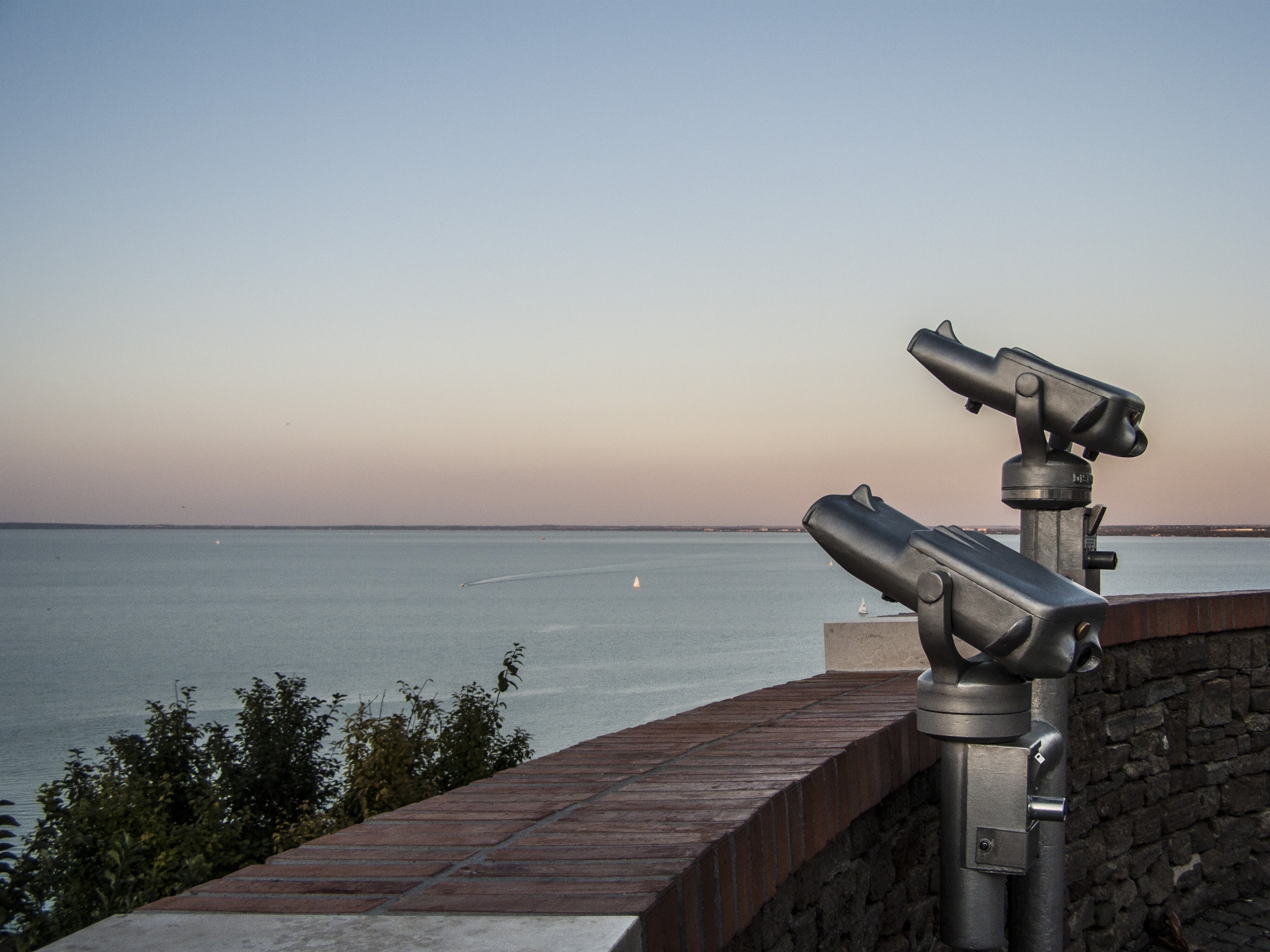 two gray telescope near body of water