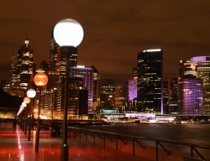 switched on street lights beside high rise buildings thumbnail