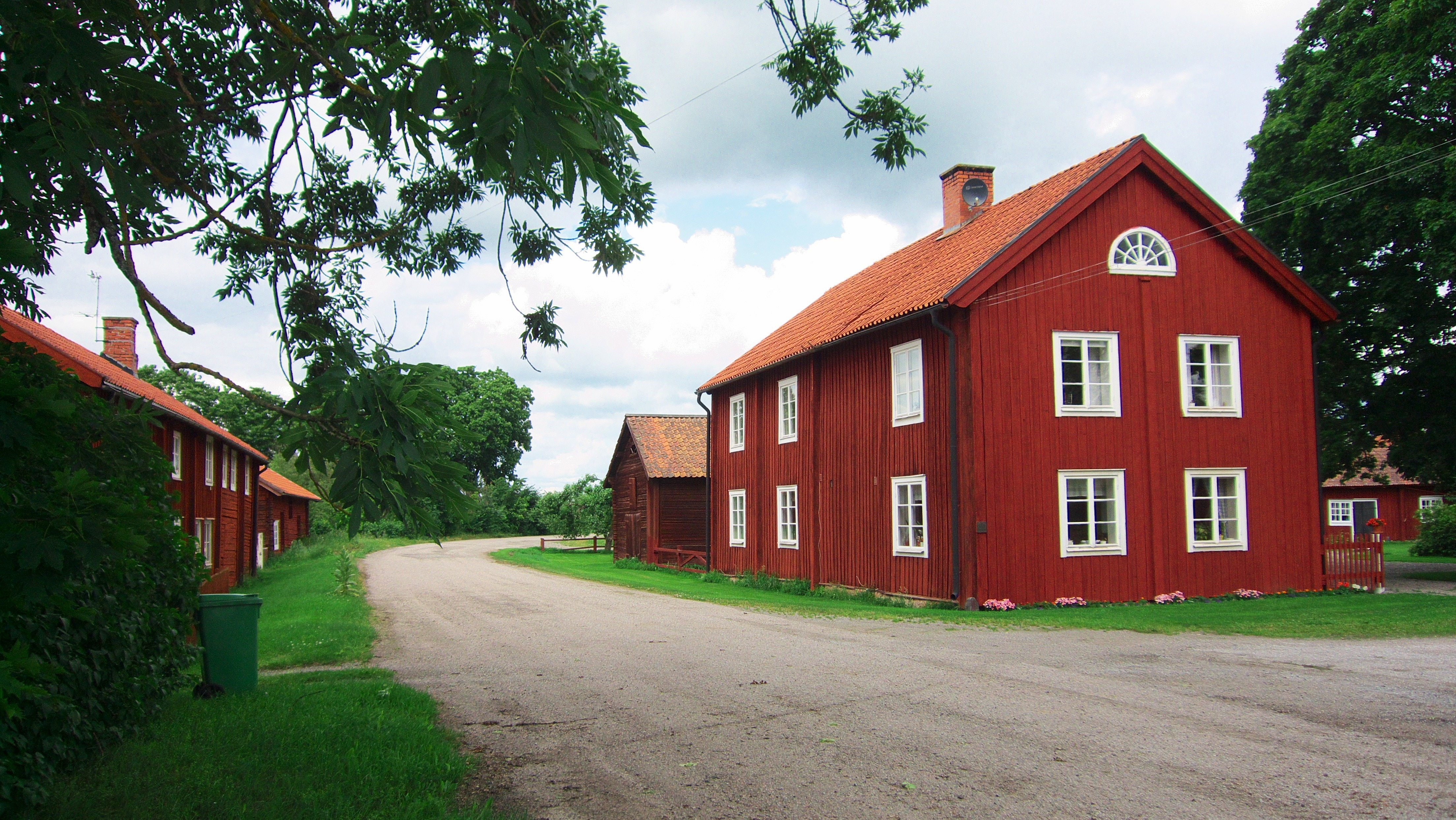 red wooden house near gravel pavement during day time