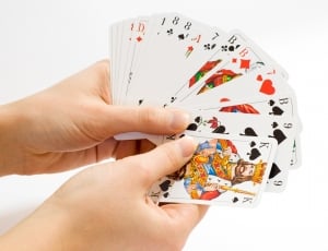 person holding playing cards thumbnail