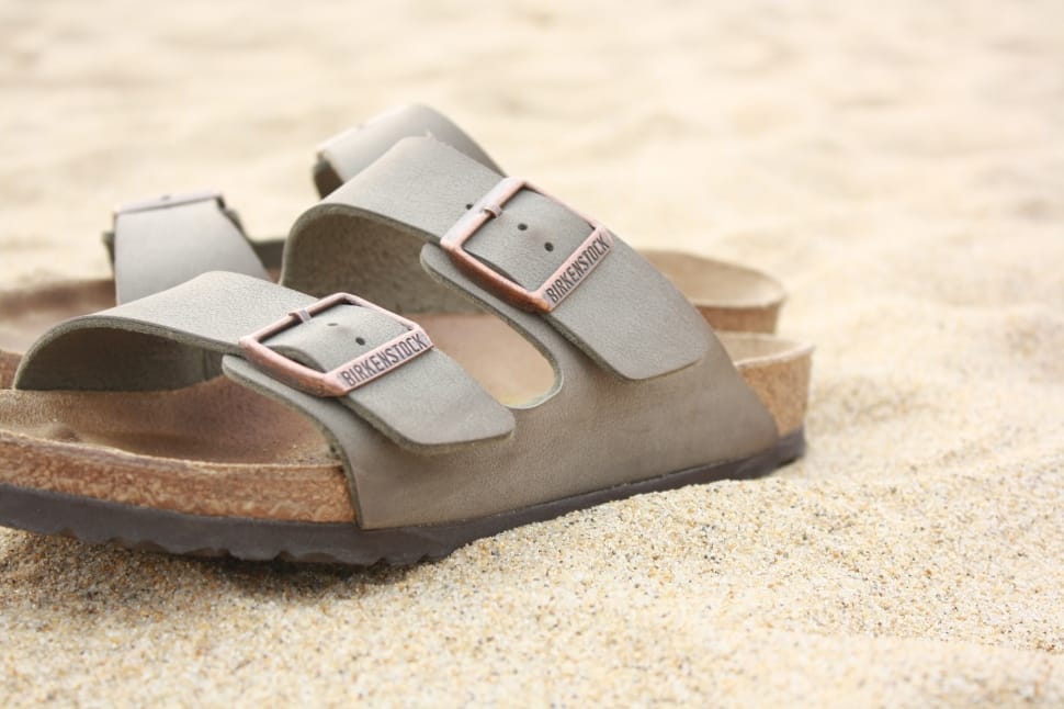 pair of gray and brown slip on sandals preview