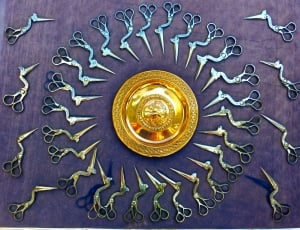 gold round emblem surrounding with scissors like thumbnail