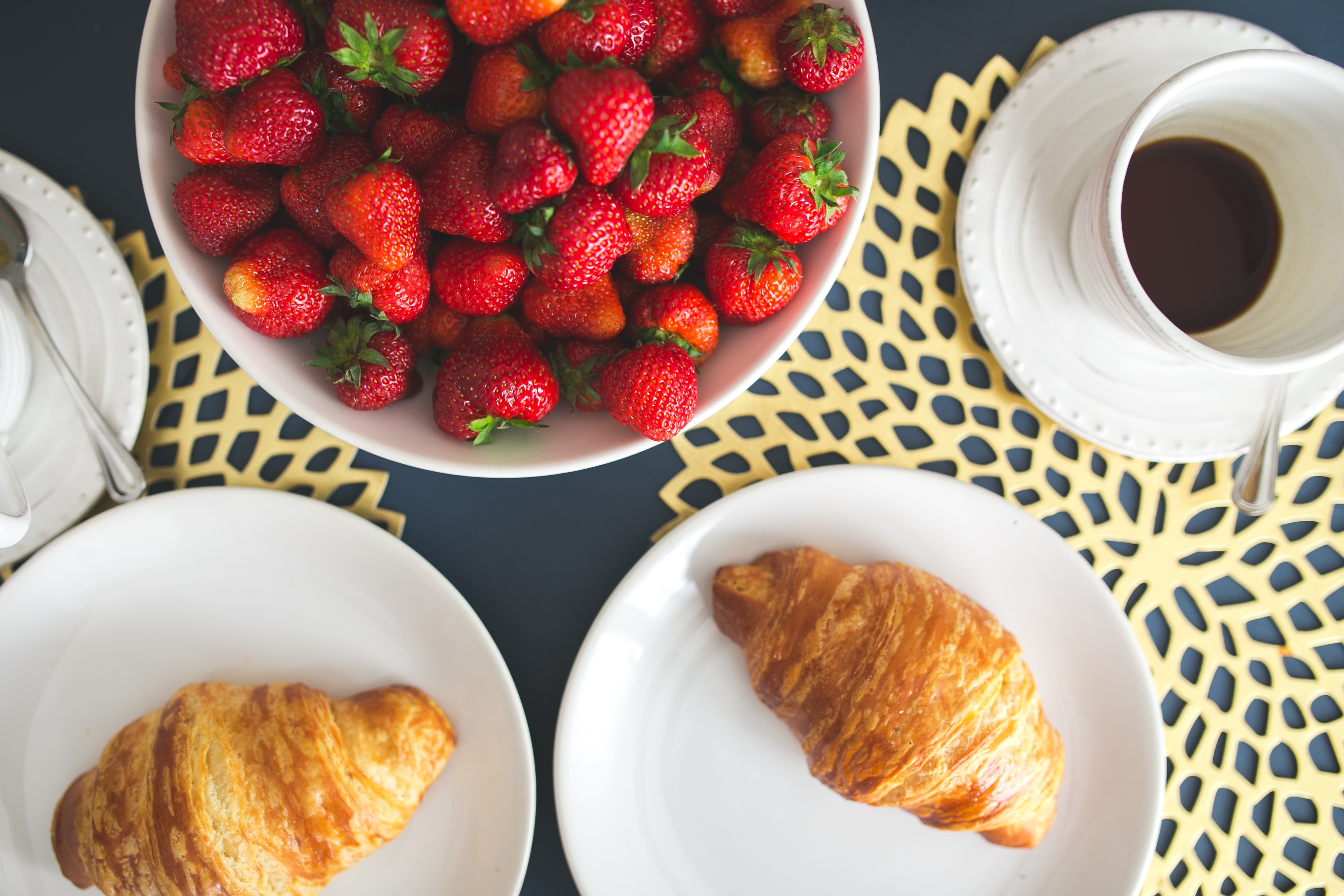 strawberries and two crossiants on table