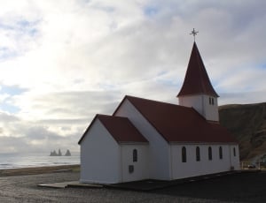 red brick roof and white wooden church thumbnail