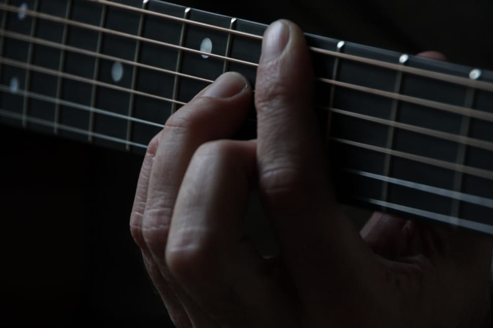 person playing guitar showing chord on fret board preview