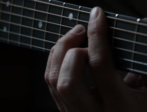 person playing guitar showing chord on fret board thumbnail
