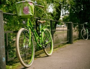 green beach cruiser bicycle  on green railings thumbnail