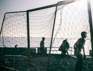 goal keeper standing in front of soccer net in grayscale photography thumbnail