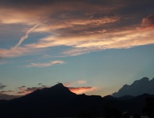 silhouette of mountain under cloudy sky during sunset thumbnail