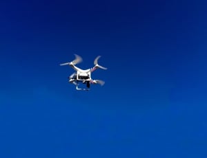 flying white quadcopter  during daytime thumbnail