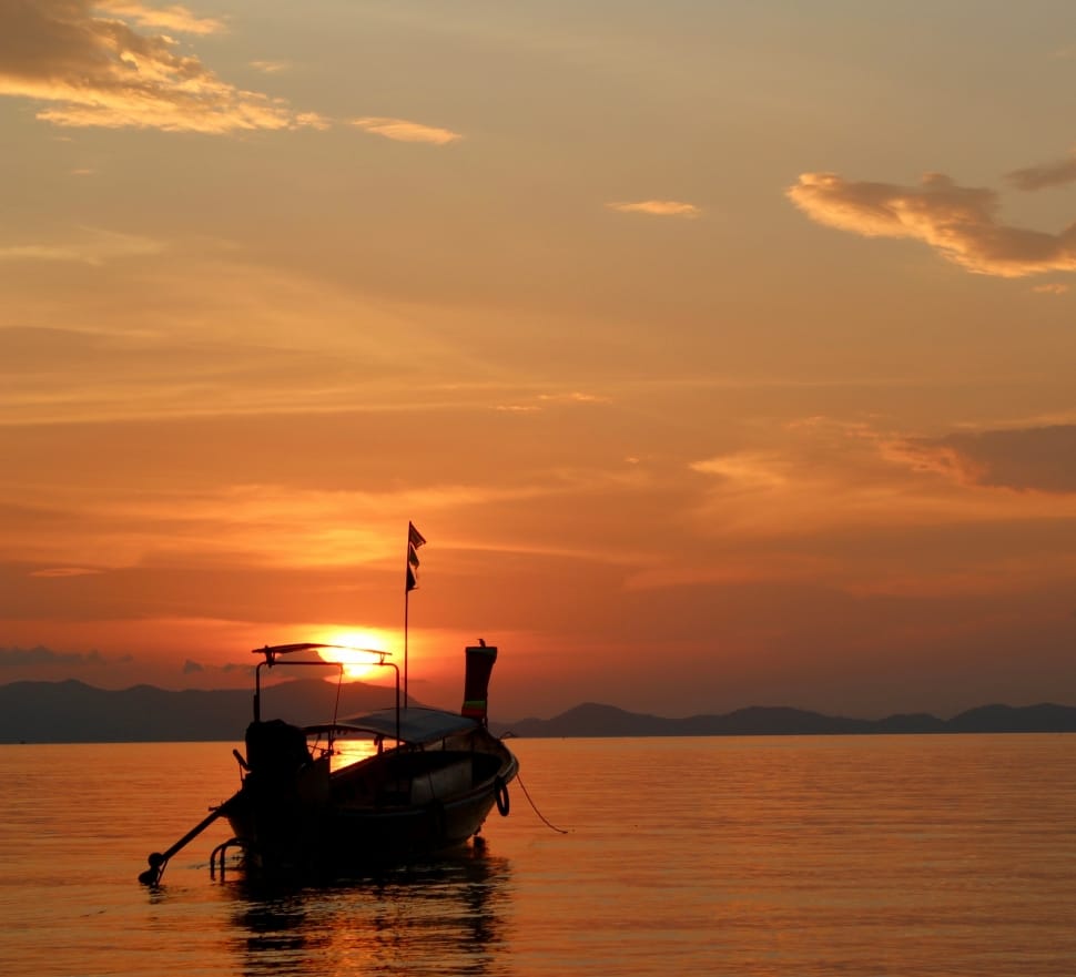 silhouette of motorboat during golden hour preview