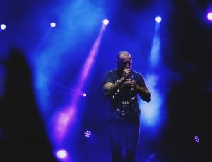 man in black shirt singing in a concert thumbnail