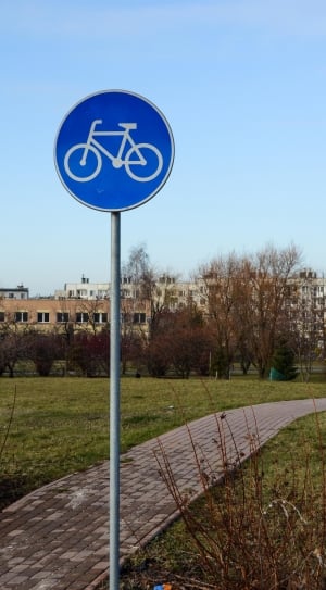 blue round bicycle signage on green grass field thumbnail