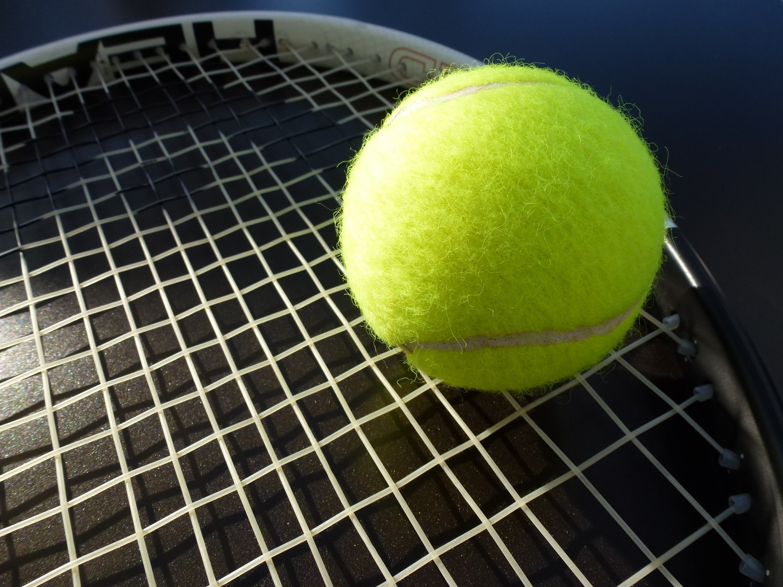 green lawn tennis ball and head lawn tennis racket
