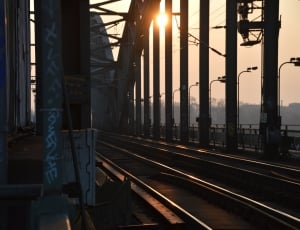 silver train rail bridges during daytime thumbnail