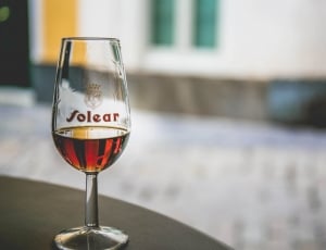 clear  folear wine glass with red liquid inside in macro shot photography thumbnail