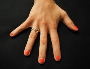 orange nail polish and silver love ring thumbnail