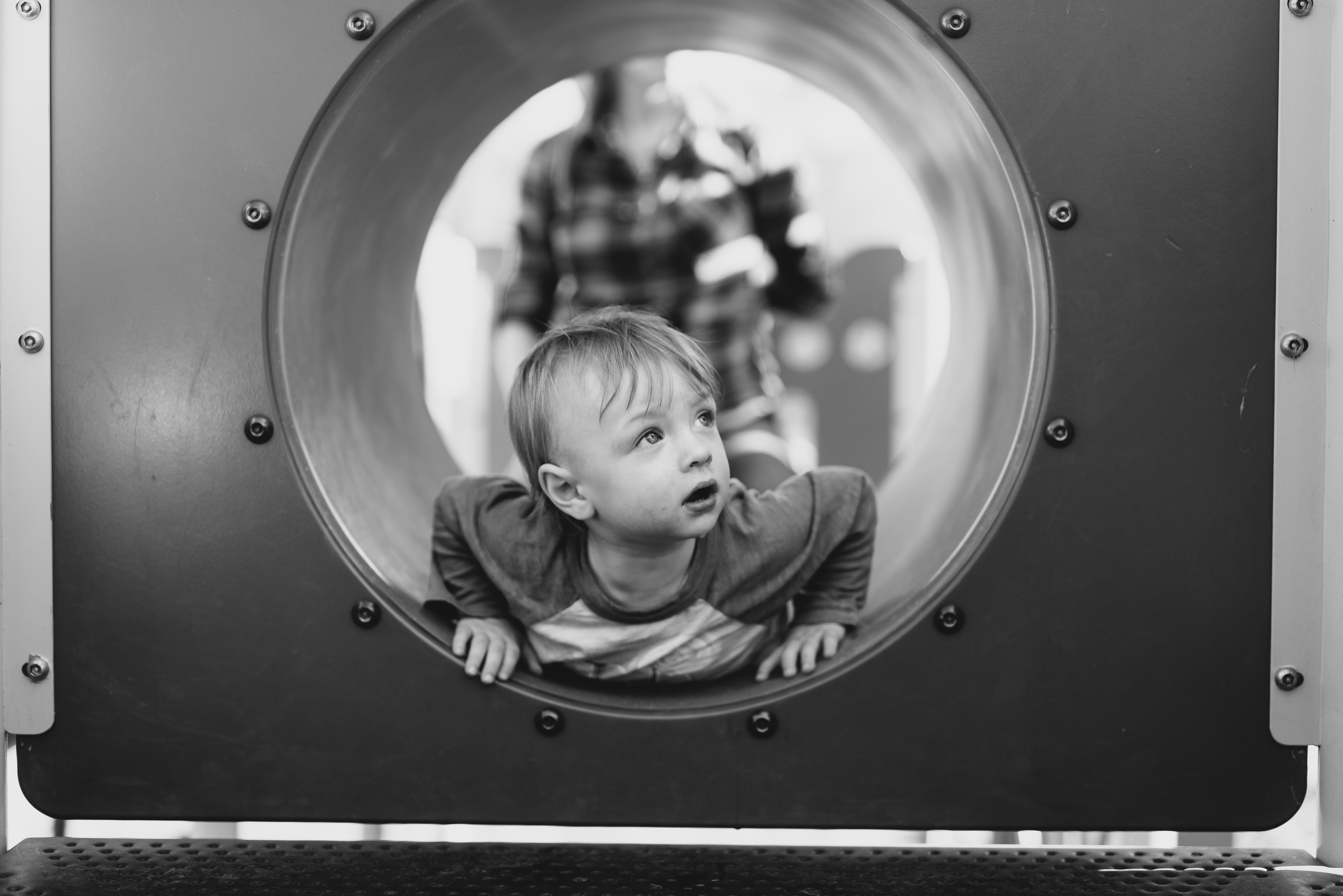 grayscale photo of a boy in tunnel