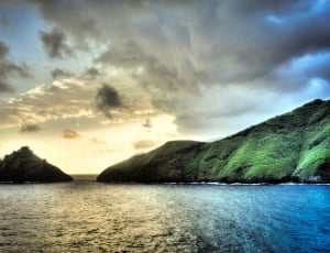 photography of island near body of water under clouds thumbnail