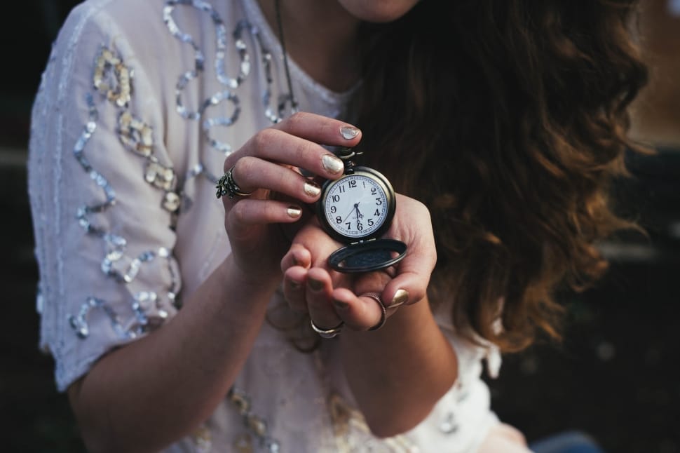 woman holding round pocket watch preview