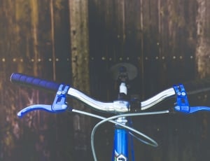 blue and gray bike near brown wooden wall thumbnail