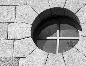 gray concrete bricked wall with round glass window thumbnail
